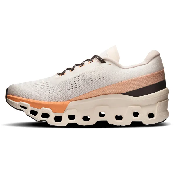 Tênis desportivo branco com detalhes cor de pêssego e preto e sola grossa com buracos hexagonais.