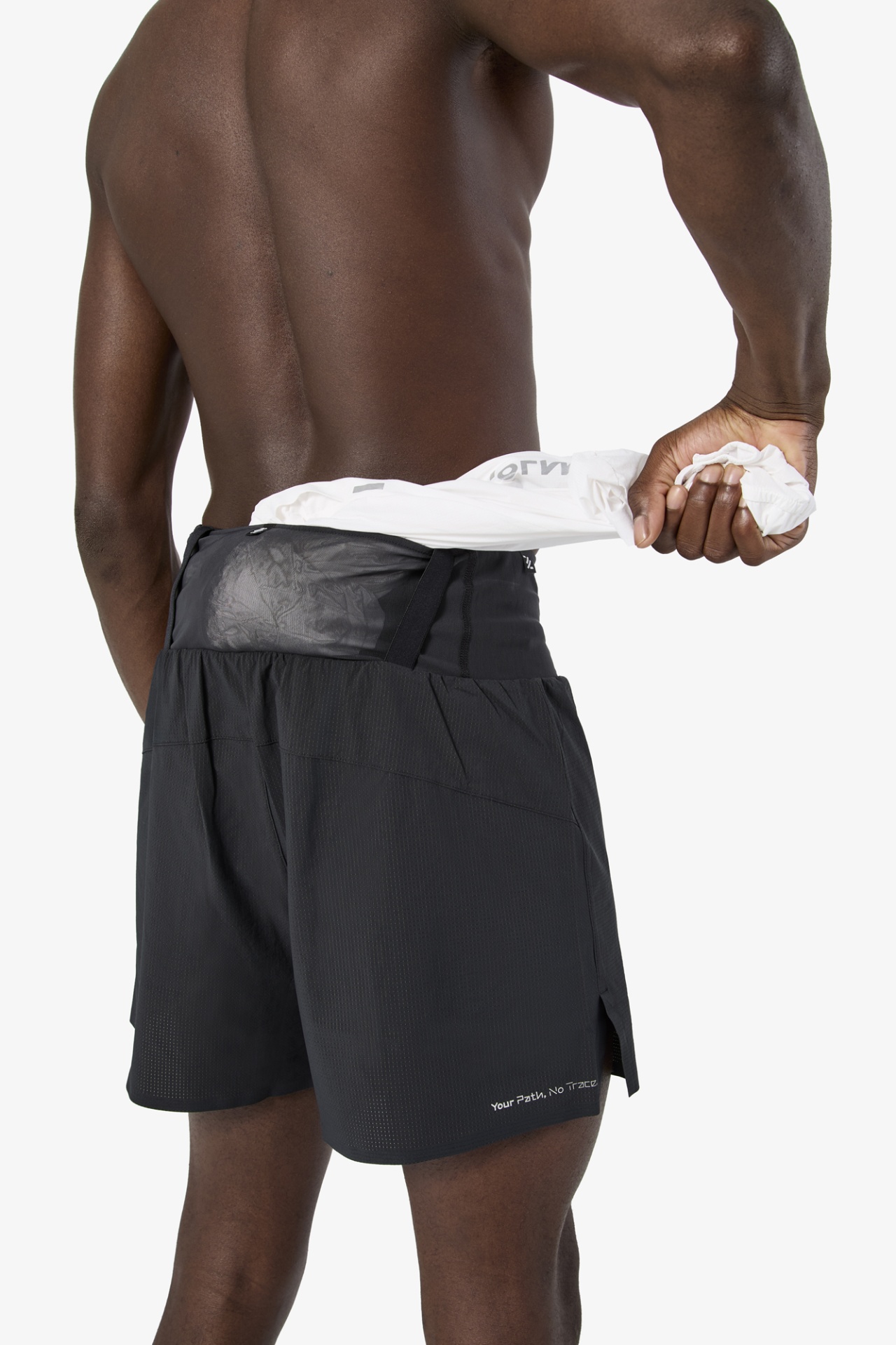 Homem a usar calções pretos com texto branco e a puxar uma peça de roupa branca