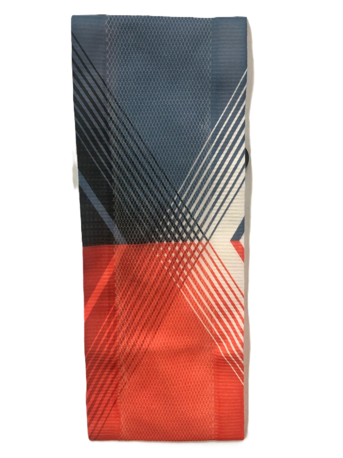 Lenço dobrado com padrão geométrico colorido em azul, vermelho, branco e preto