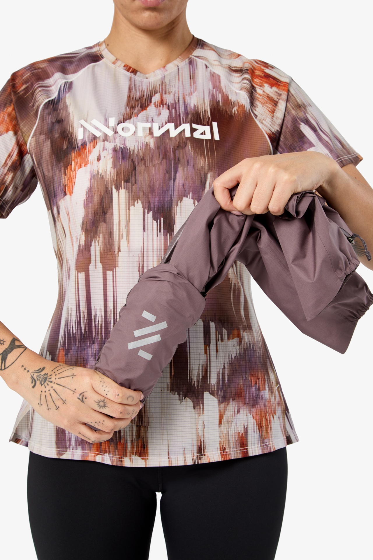 Pessoa com t-shirt desportiva e segura casaco ou saco roxo