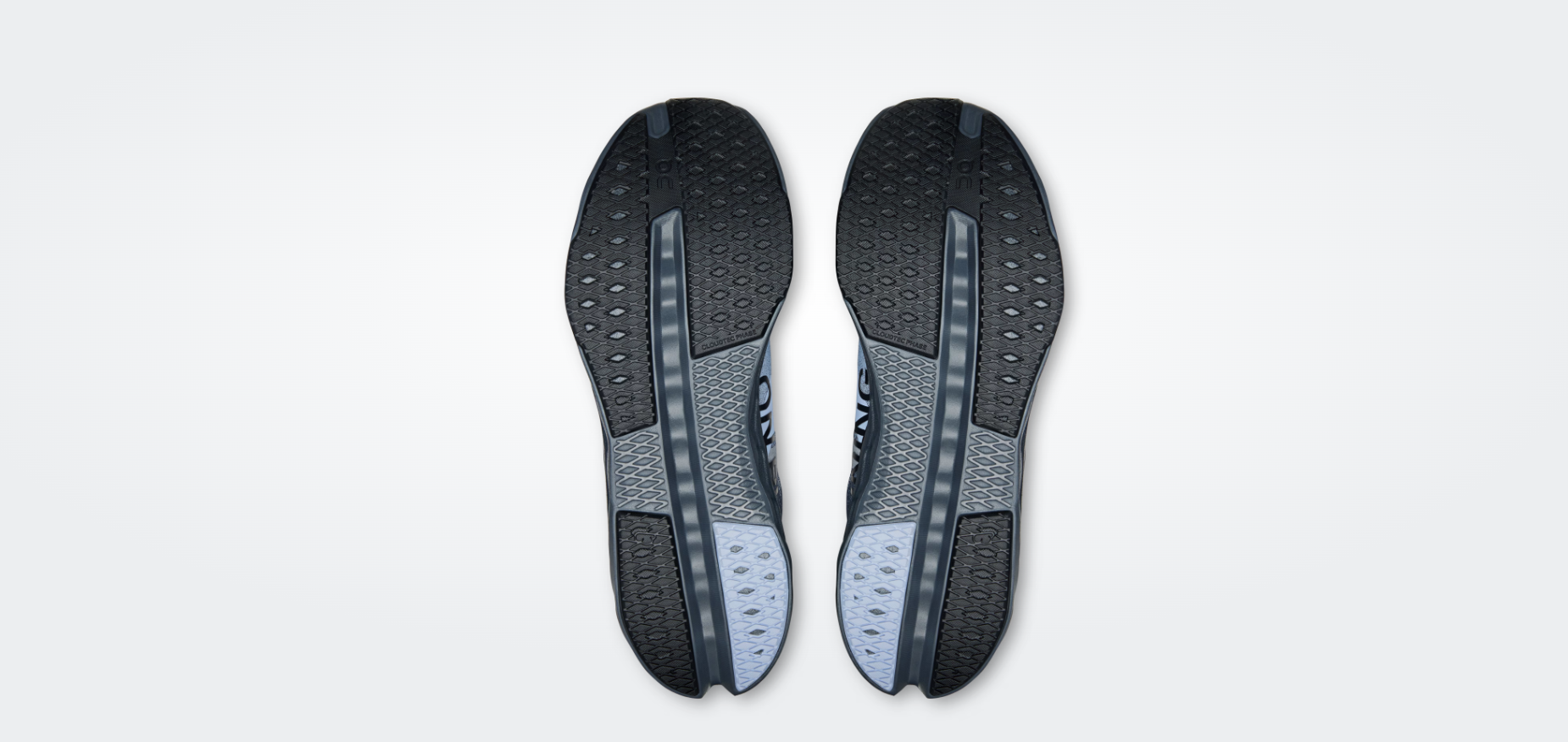 Solas de sapatos em borracha preta e cinzenta com padrão em losango e texto CLOUDFTEC PHASE.