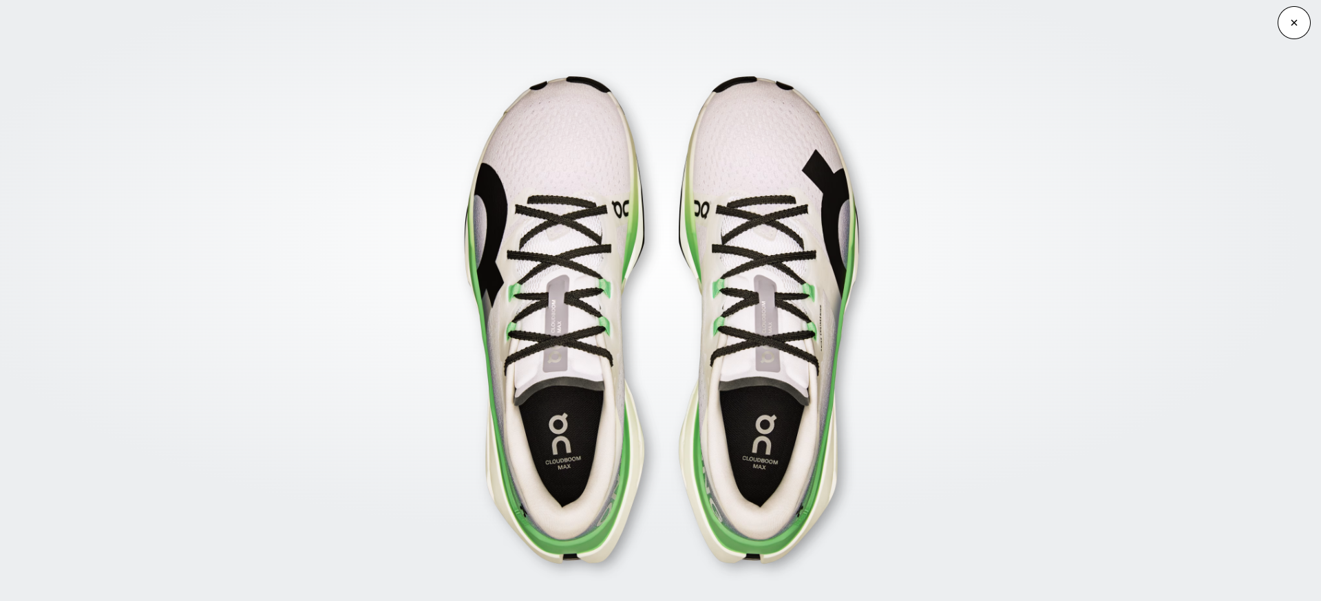 Ténis desportivos brancos e verdes com atacadores pretos vistos de cima