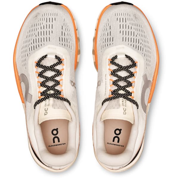 Ténis desportivos brancos com sola laranja e atacadores pretos