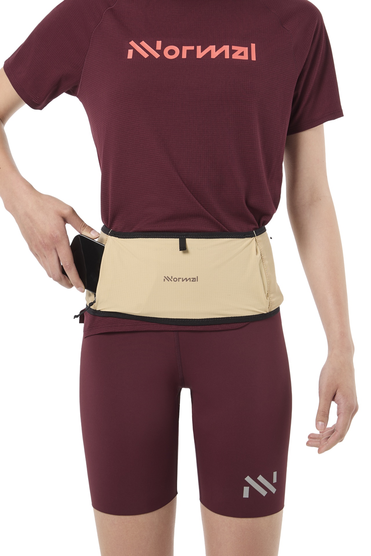 Pessoa a vestir roupa desportiva borgonha e a colocar smartphone num cinto bege com texto Normal
