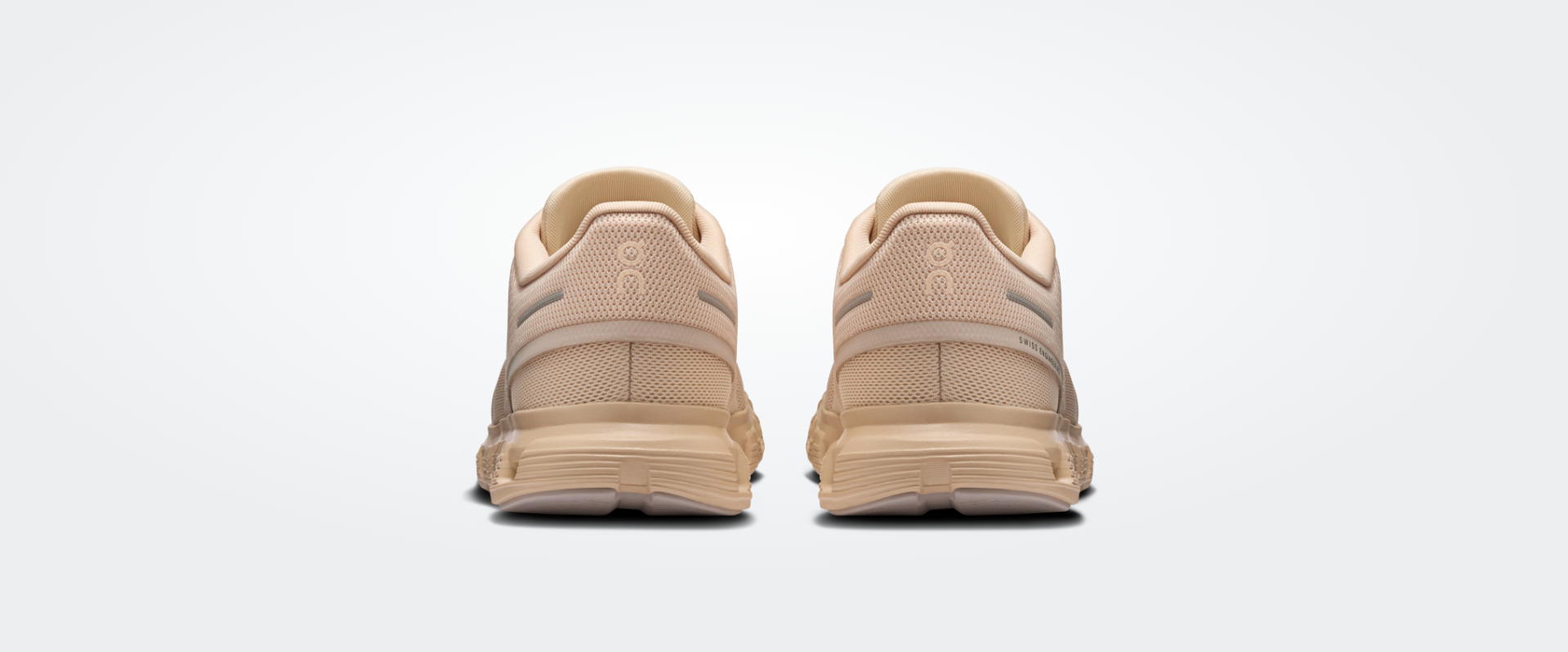 Sapatilhas desportivas bege claro vistas por trás com sola antiderrapante.