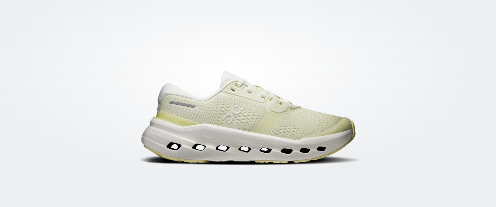 Tênis desportivo amarelo claro e branco com sola perfurada e logótipo on