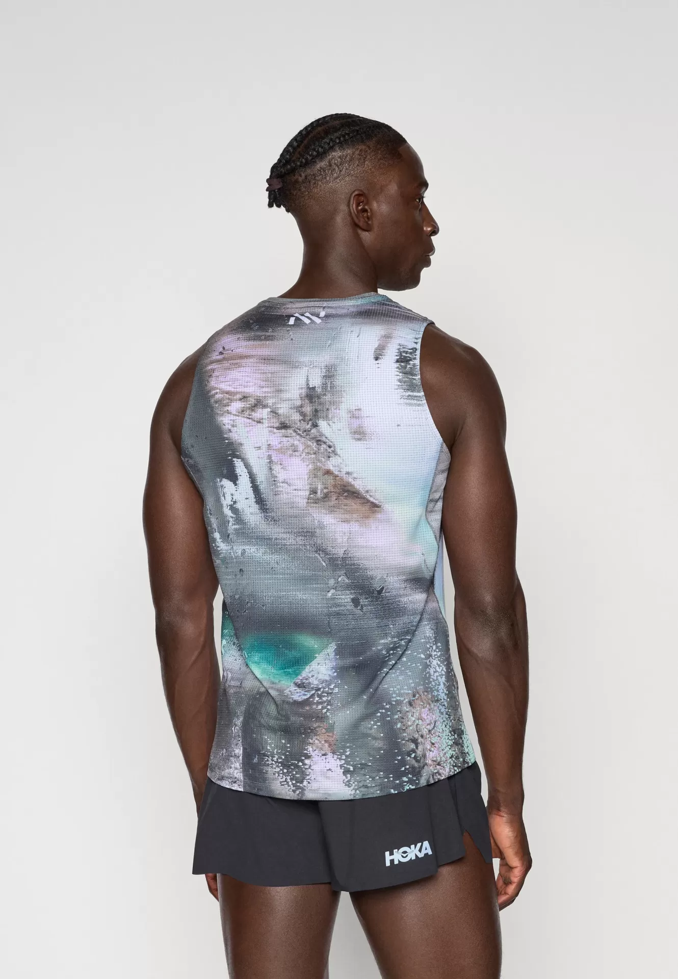 Camisola de alças desportiva com padrão abstrato e calções pretos com logotipo HOKA