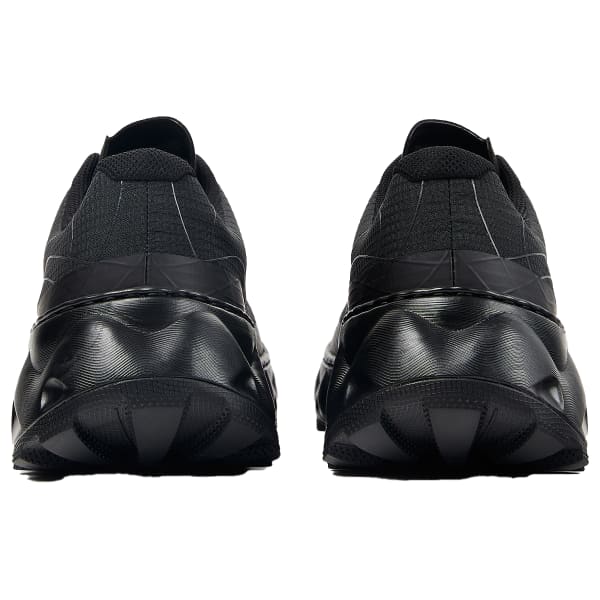 Ténis pretos vistos de trás com sola espessa e parte superior em malha.