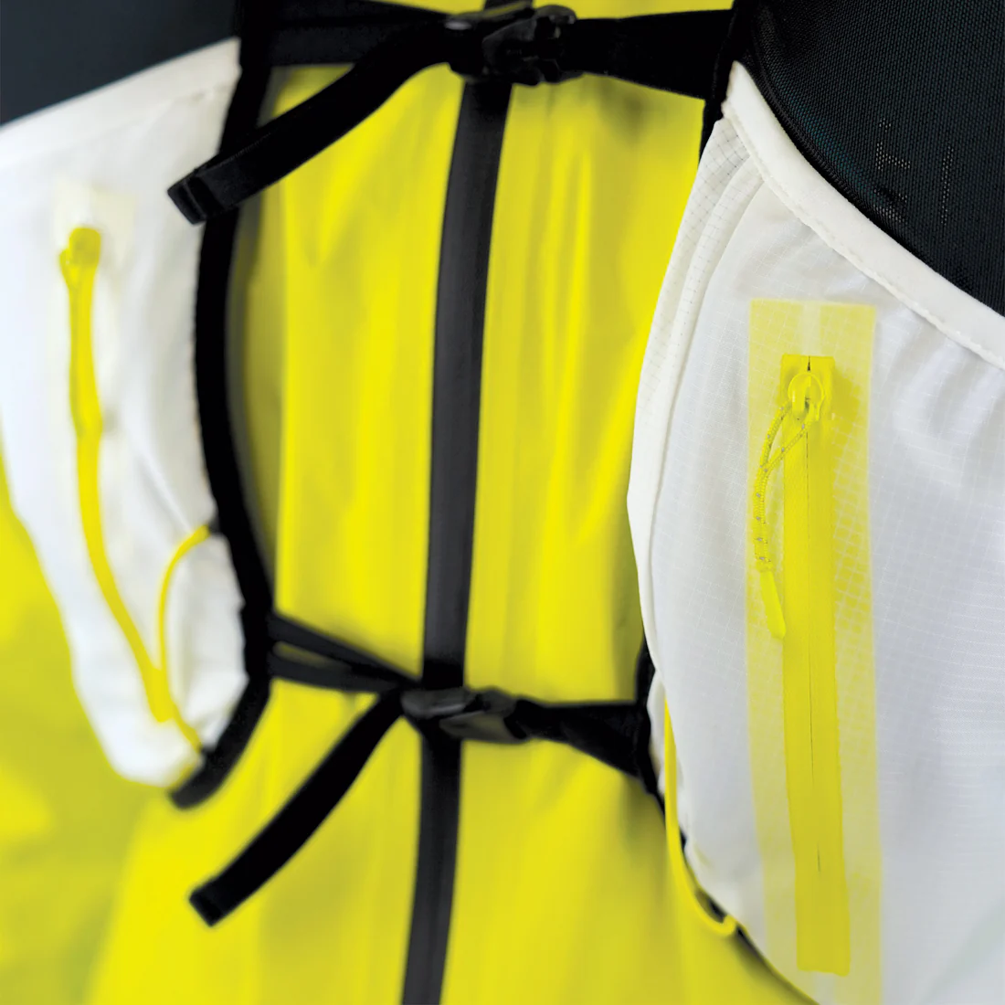 Mochila técnica amarela, branca e preta com detalhes em fechos e tirantes