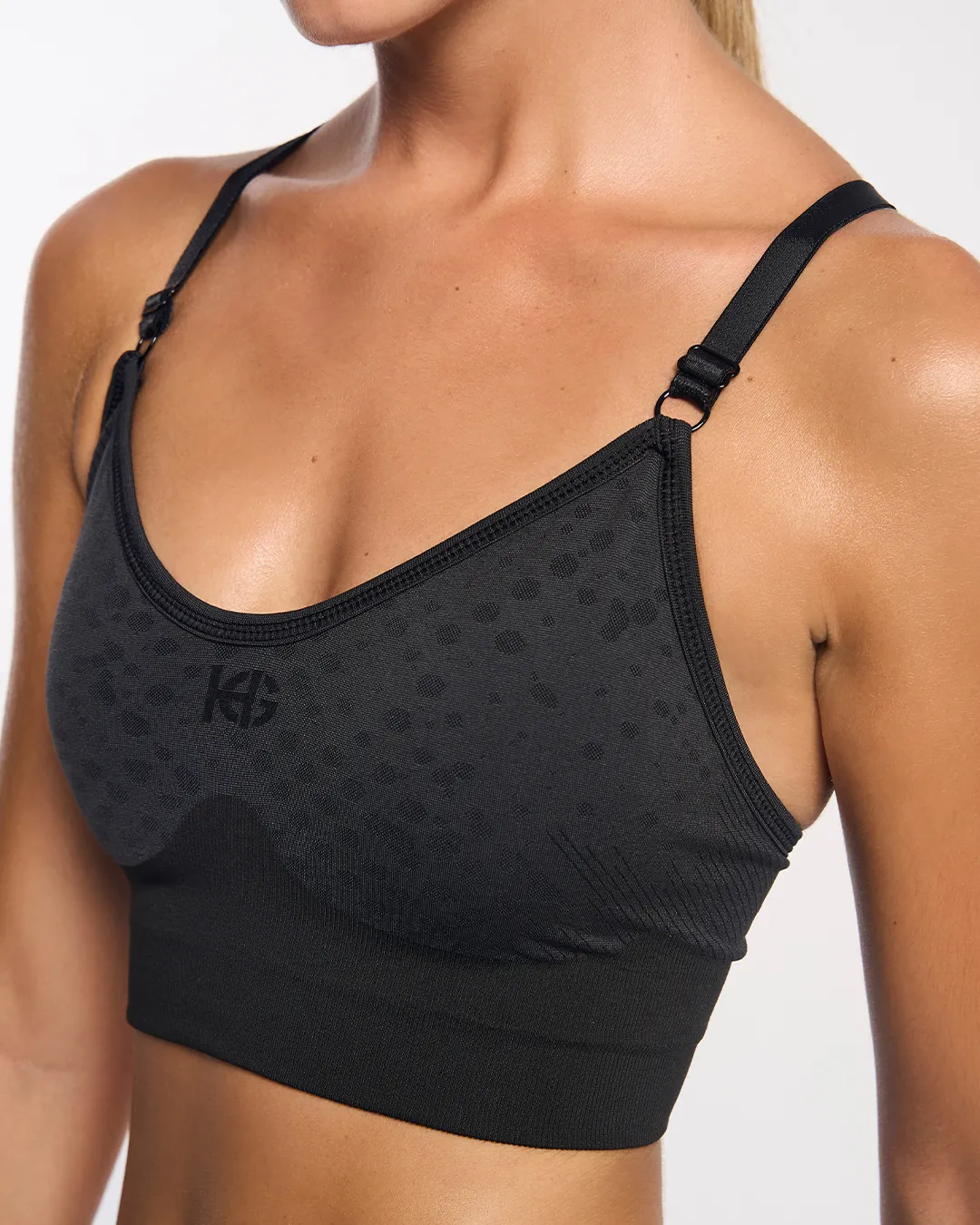 Top desportivo preto com padrão discreto e alças ajustáveis