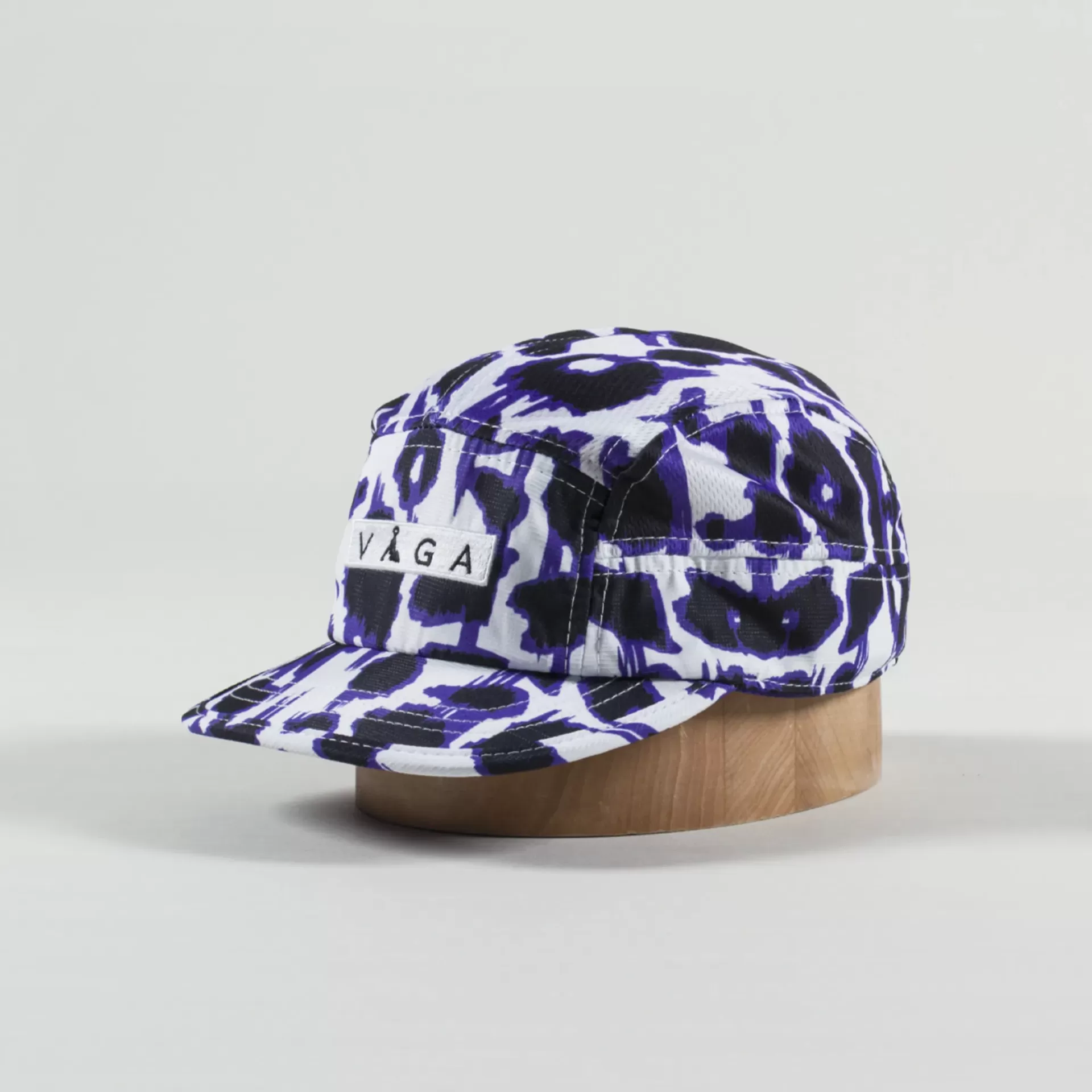 Boné em tecido com padrão azul, branco e preto e etiqueta VAGA