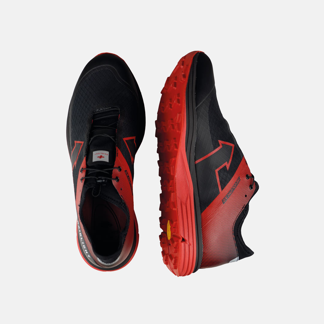 Sapatilhas desportivas preta e vermelha com sola vermelha em fundo branco