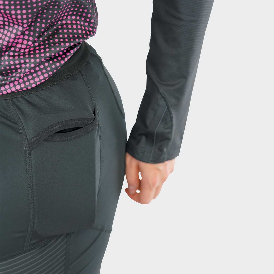 Roupas desportivas justas, calças pretas com bolso aberto e manga comprida preta com punho.