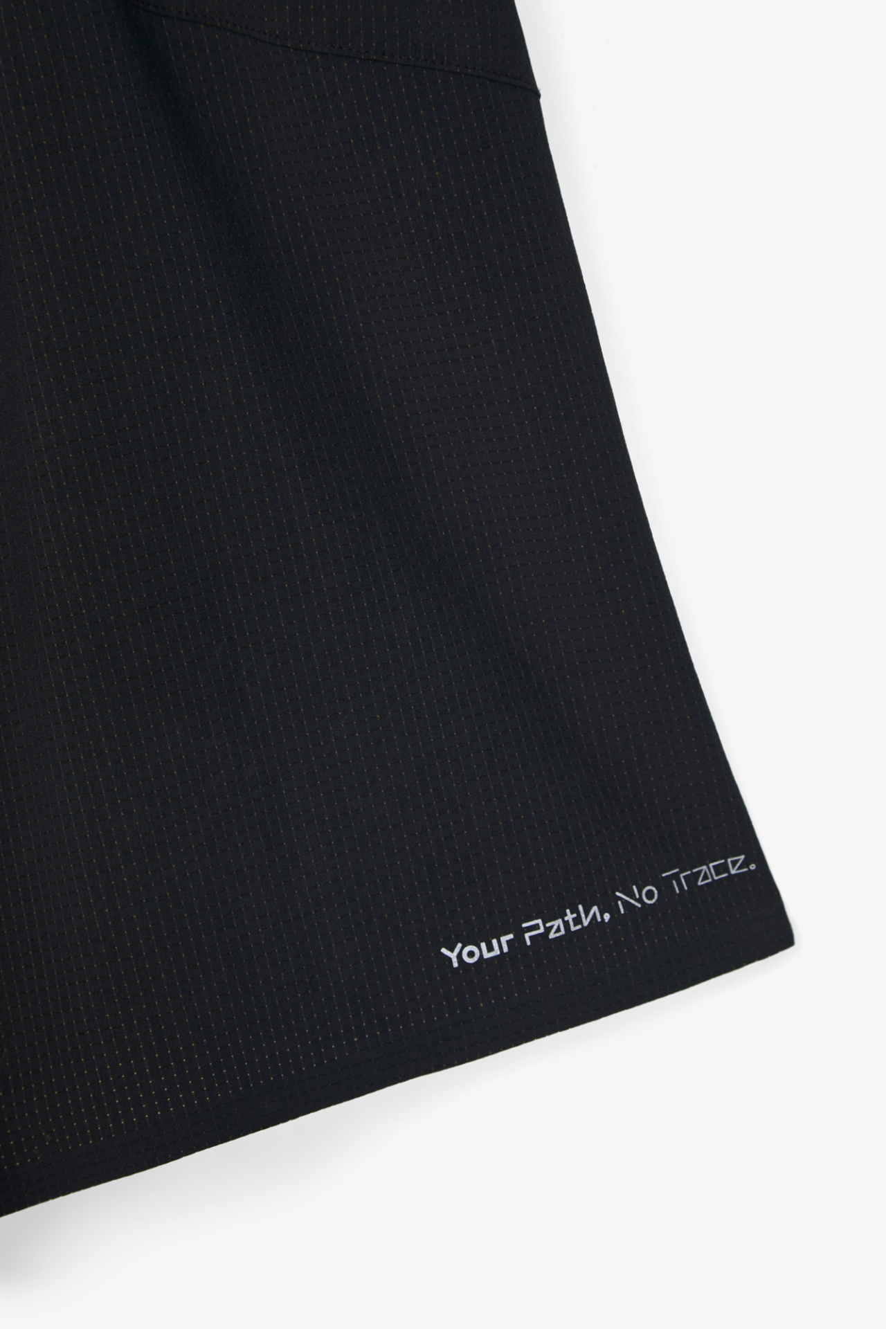 Pano preto com padrão quadriculado amarelo e texto branco Your Path, No Trace.