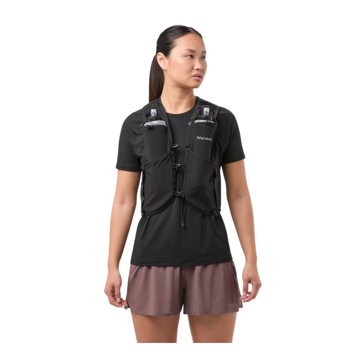 Mulher com colete de hidratação preto, t-shirt preta e calções castanhos