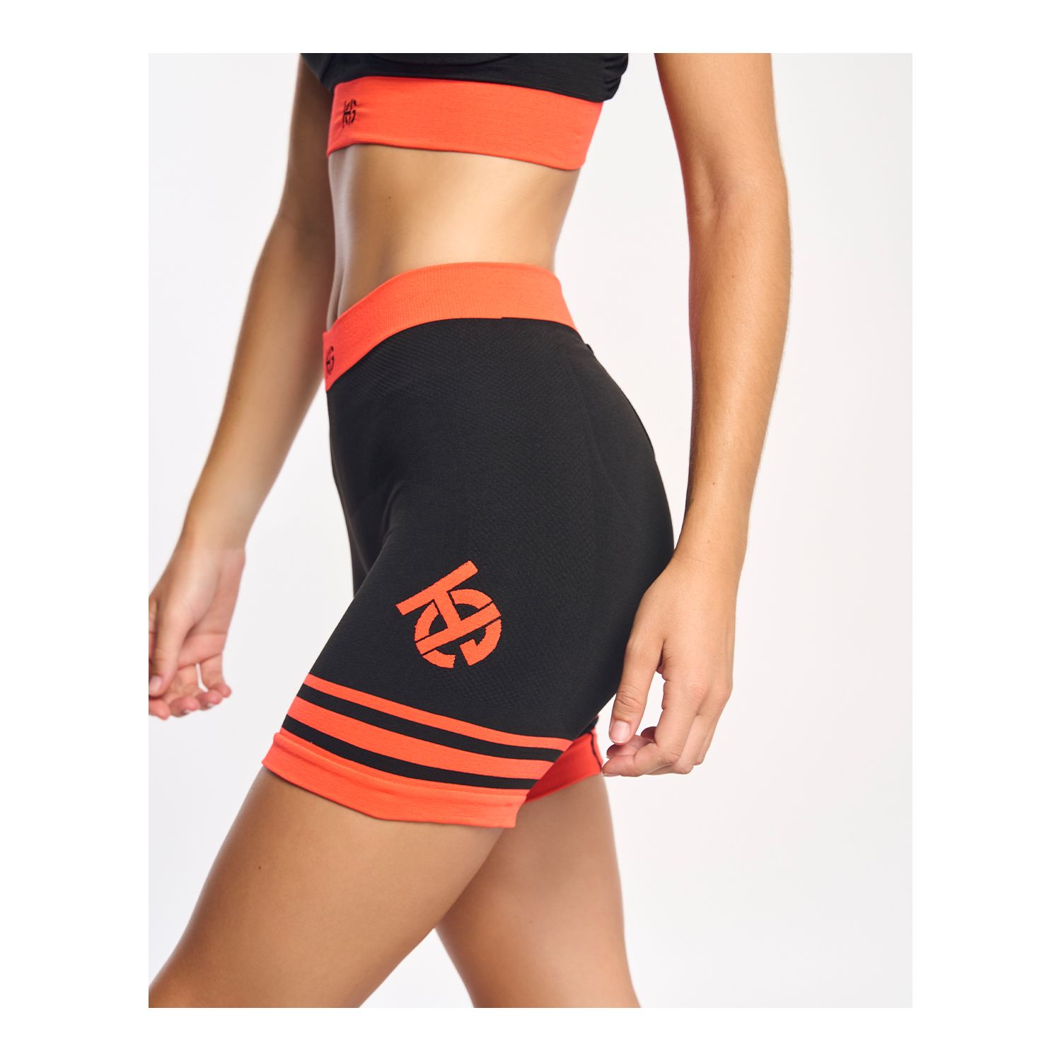 Conjunto de desporto preto com detalhes laranja em modelo feminino