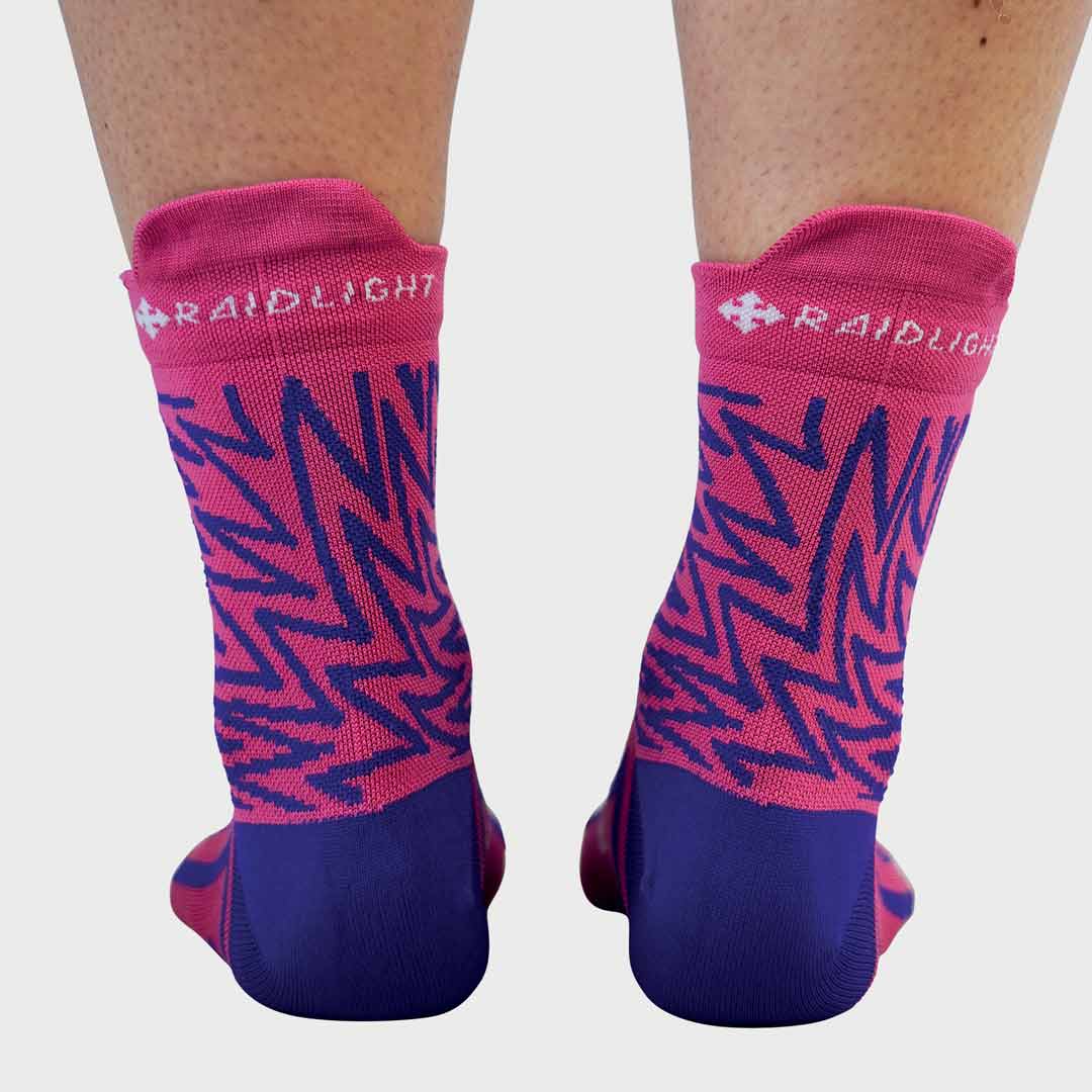 Meias desportivas rosa e azul roxo com padrão zig-zag e texto RAIDLIGHT