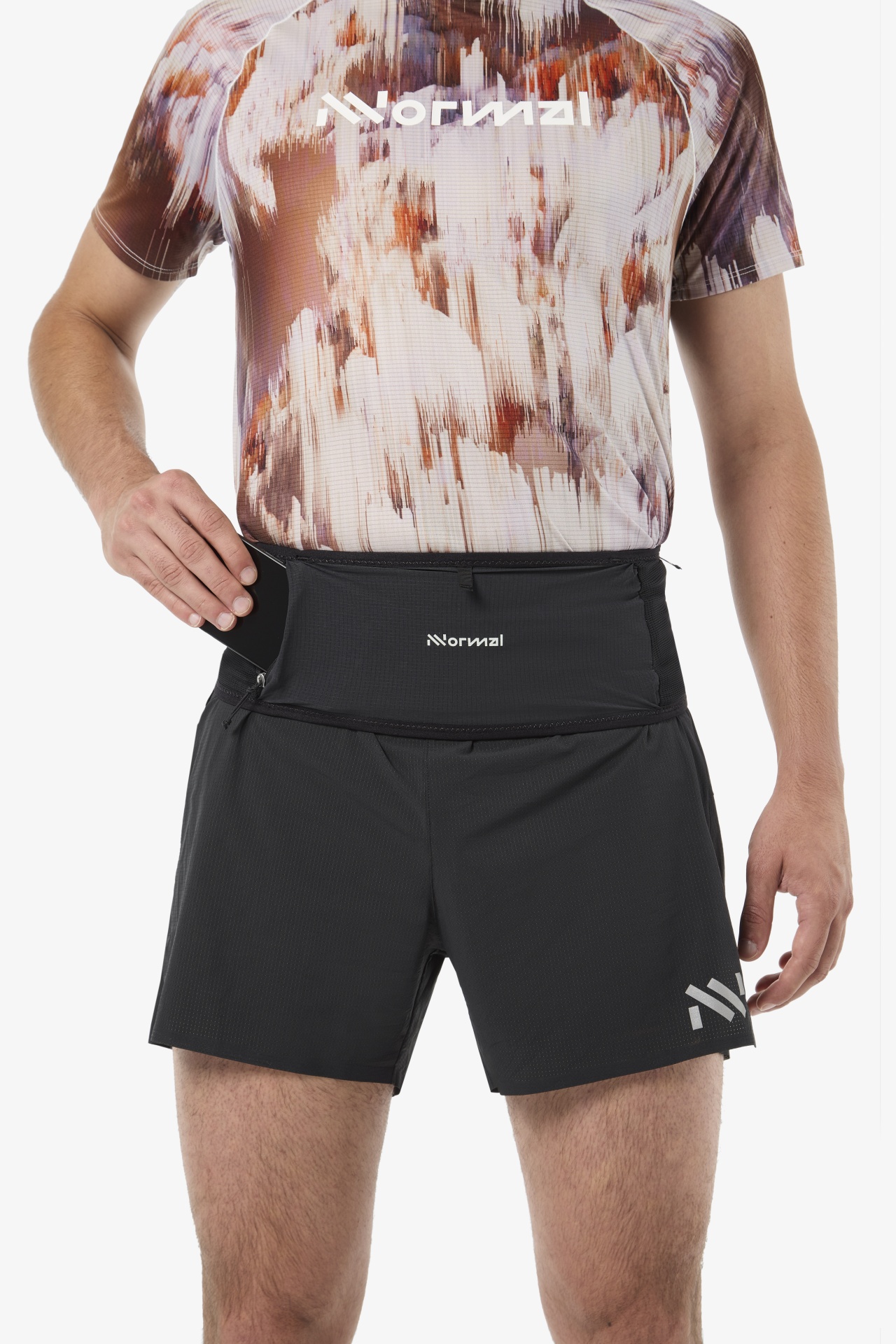 Homem com calções pretos e cinto com bolso, t-shirt estampada colorida com logo Normal.