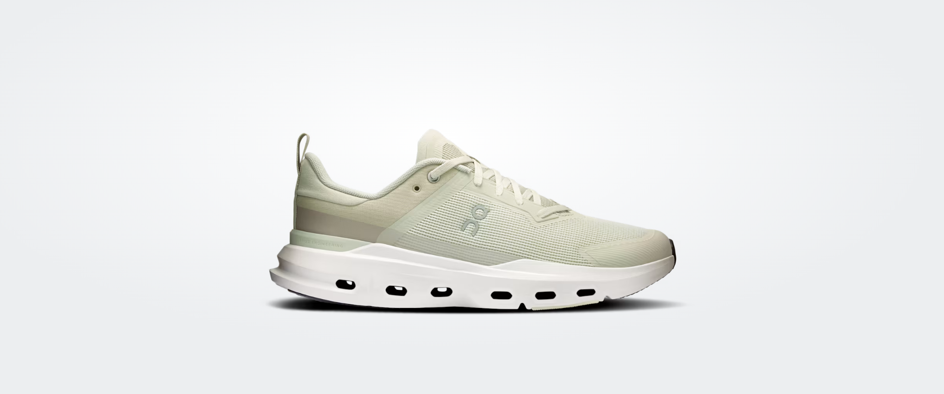 Ténis de corrida branco com detalhes em verde claro sobre fundo branco.