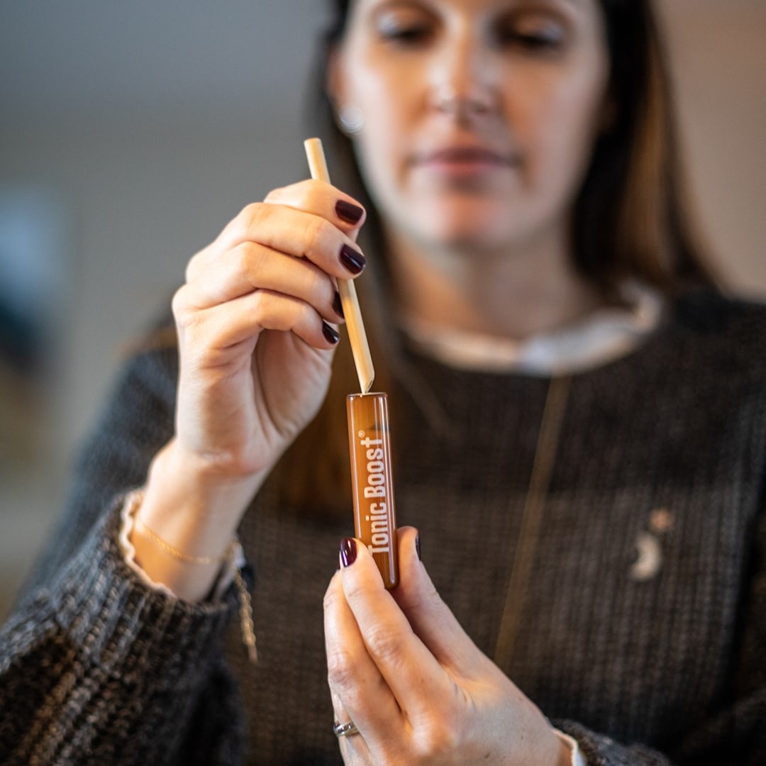 Mulher segurando frasco pequeno rotulado Ionic Boost