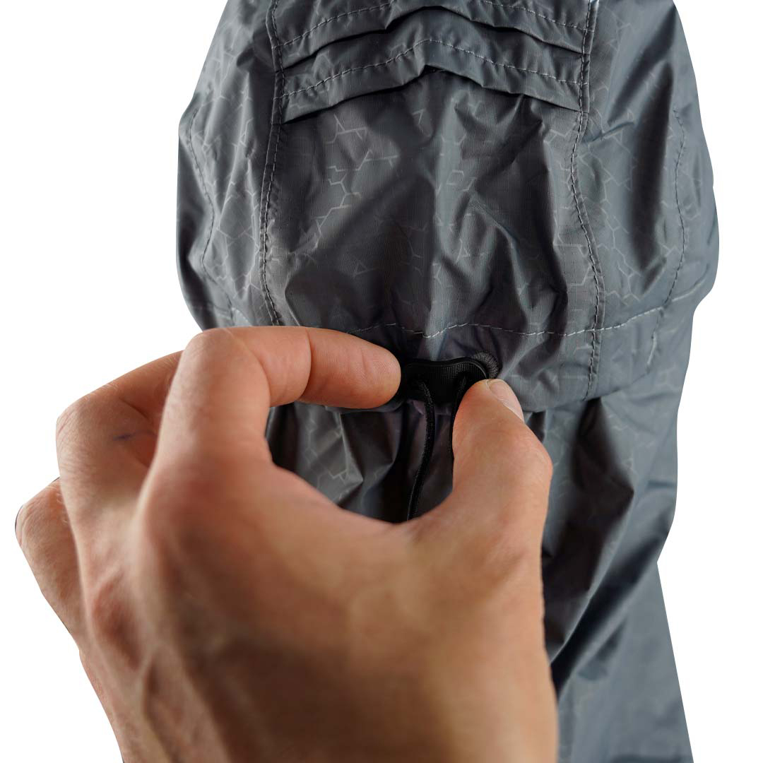 Mão ajustando cordão em capuz de casaco cinzento escuro