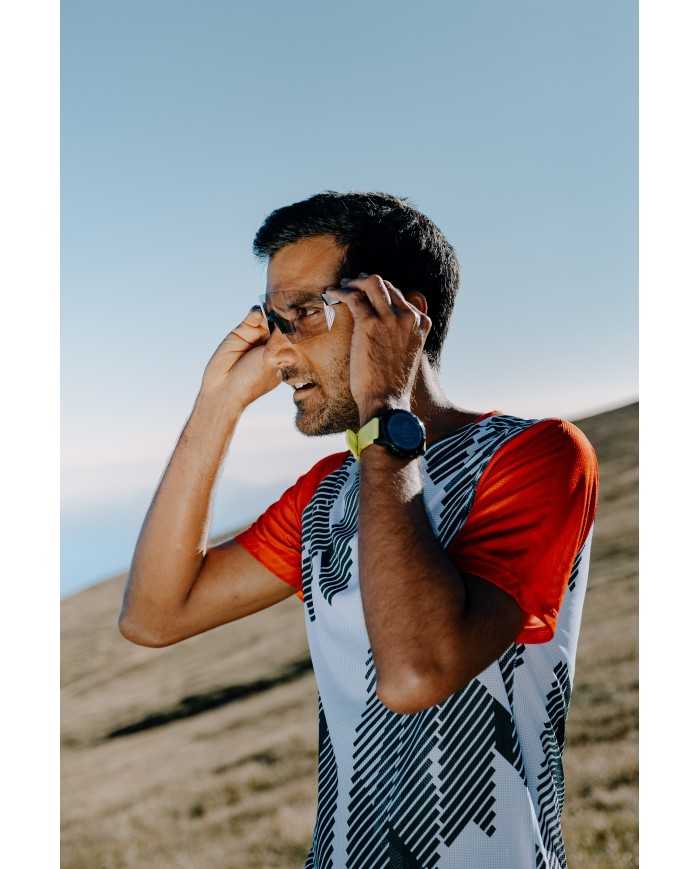 Homem com t-shirt desportiva a ajustar óculos de sol no exterior