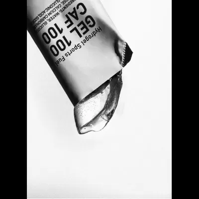 Tubo branco de gel com texto preto e gel transparente a sair