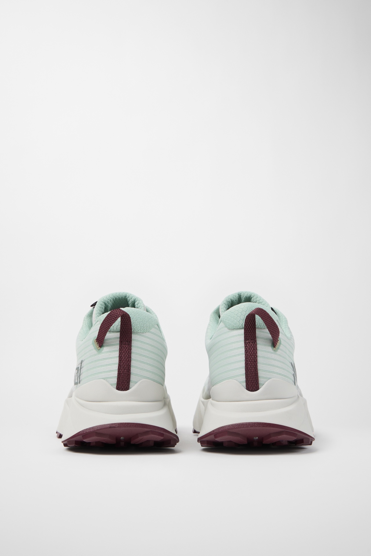 Sapatilhas desportivas verdes claras com riscas e detalhes castanhos vistas de trás