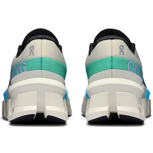 Sapatilhas brancas, azuis e verdes vistas de trás com sola grossa segmentada