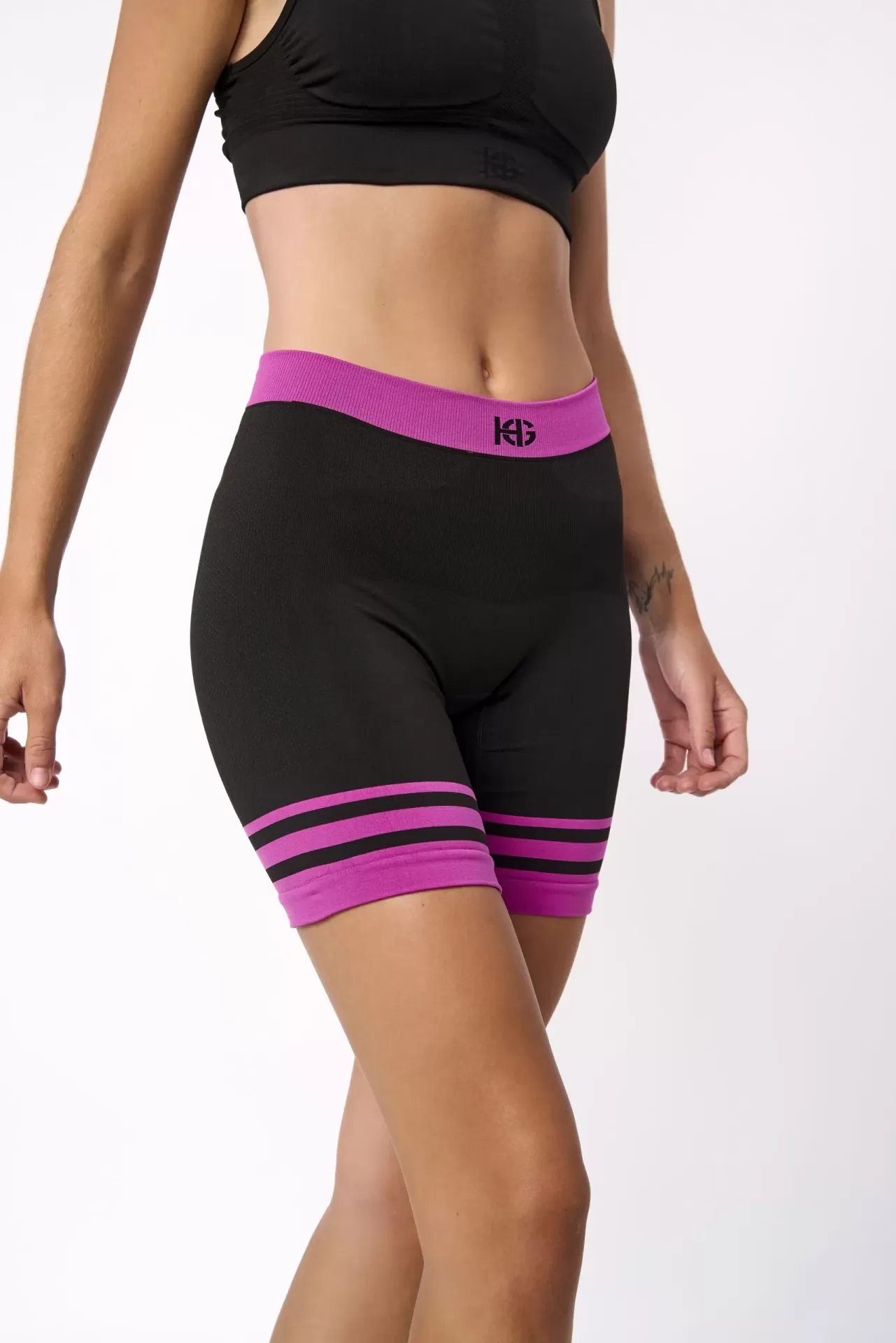 Conjunto deportivo mujer negro con detalles fucsia y logotipo HG.