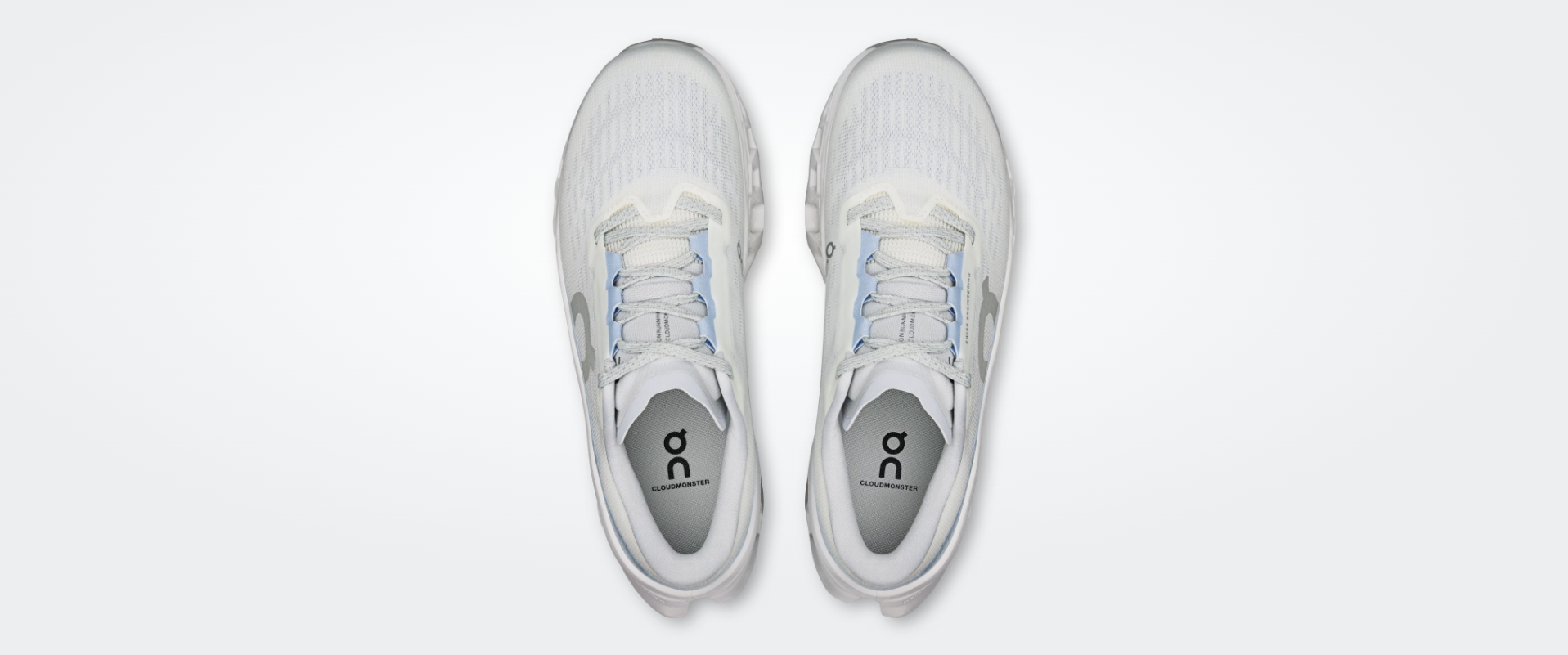 Par de sapatilhas desportivas brancas com detalhes azuis e cinza vista de cima.