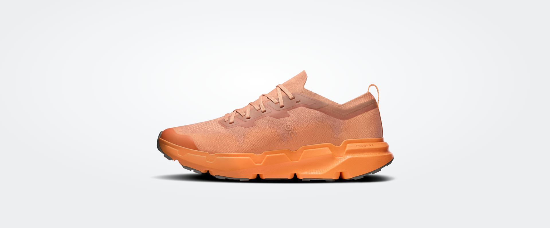 Tênis desportivo laranja com sola tratorada e cabedal em tecido knit