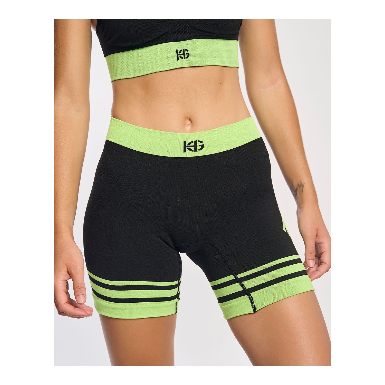 Top e calções desportivos pretos com detalhes em verde fluorescente e logotipo KG