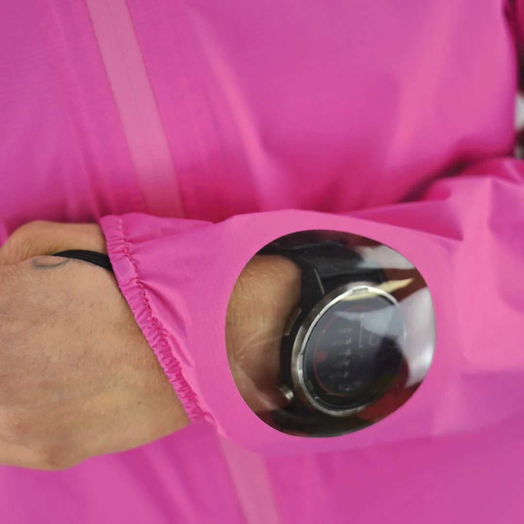 Relógio smartwatch preto num pulso visível através da manga de um casaco rosa