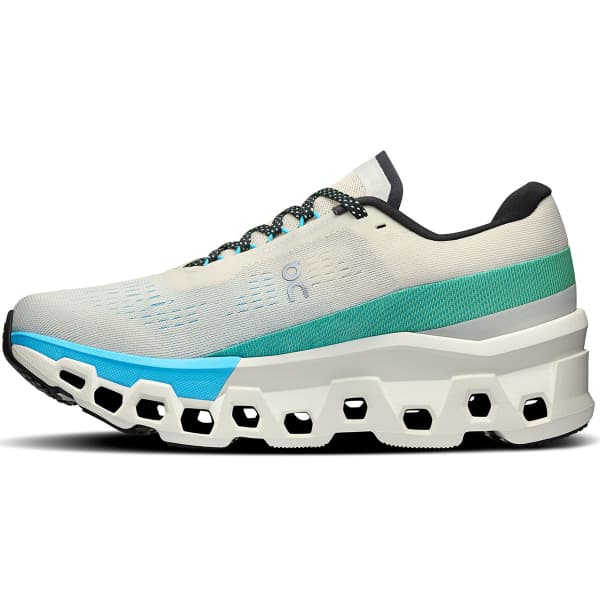 Tênis desportivo cinza claro com detalhes em verde água, azul, preto e sola grossa branca com furações.
