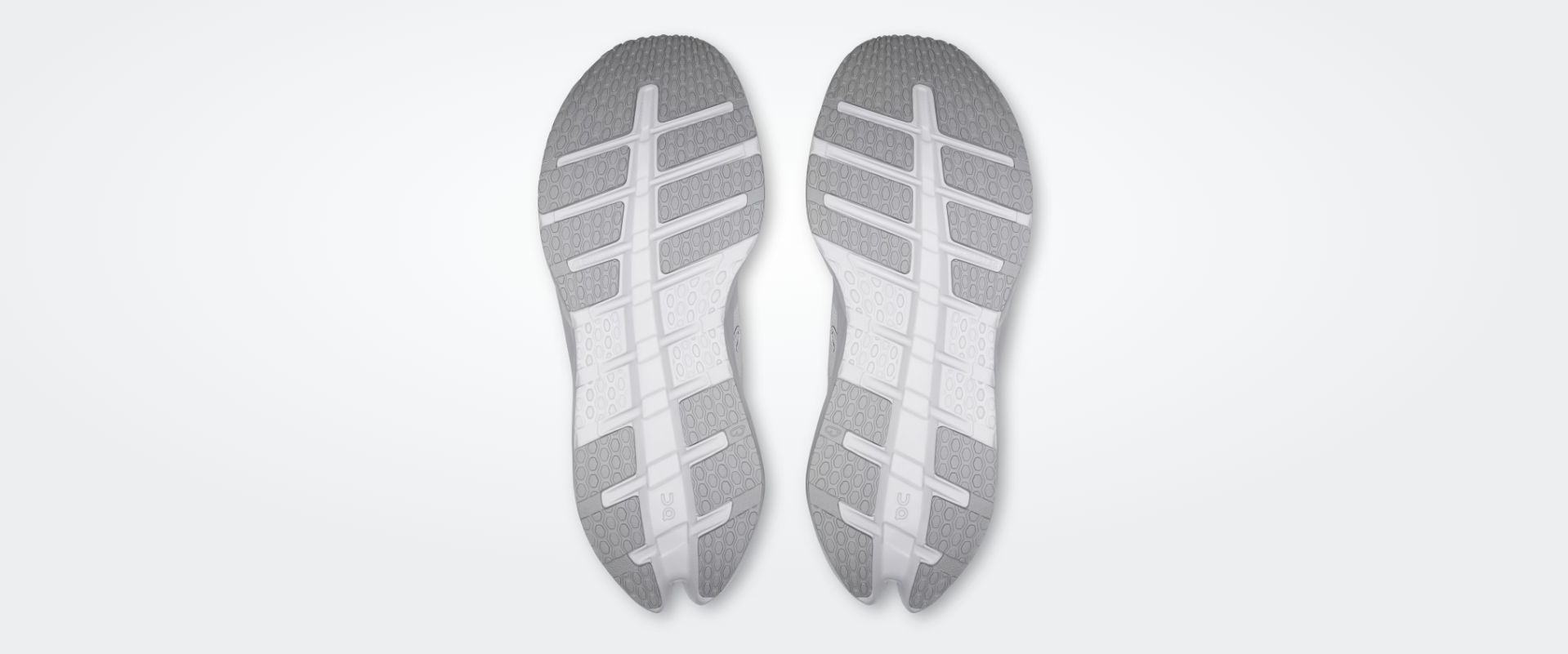Solas de ténis desportivos cinzentos e brancos com padrão texturizado