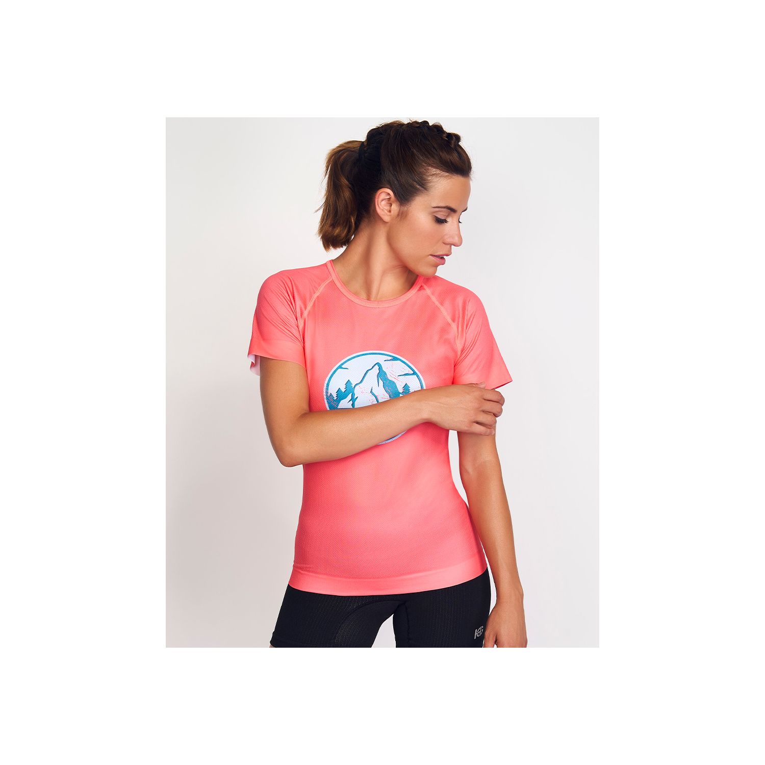 Camisola desportiva rosa com estampa de montanhas usada por mulher