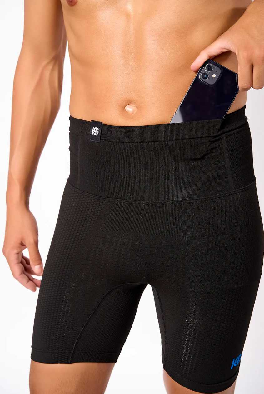 Homem a colocar telemóvel em calções pretos justos com bolso lateral