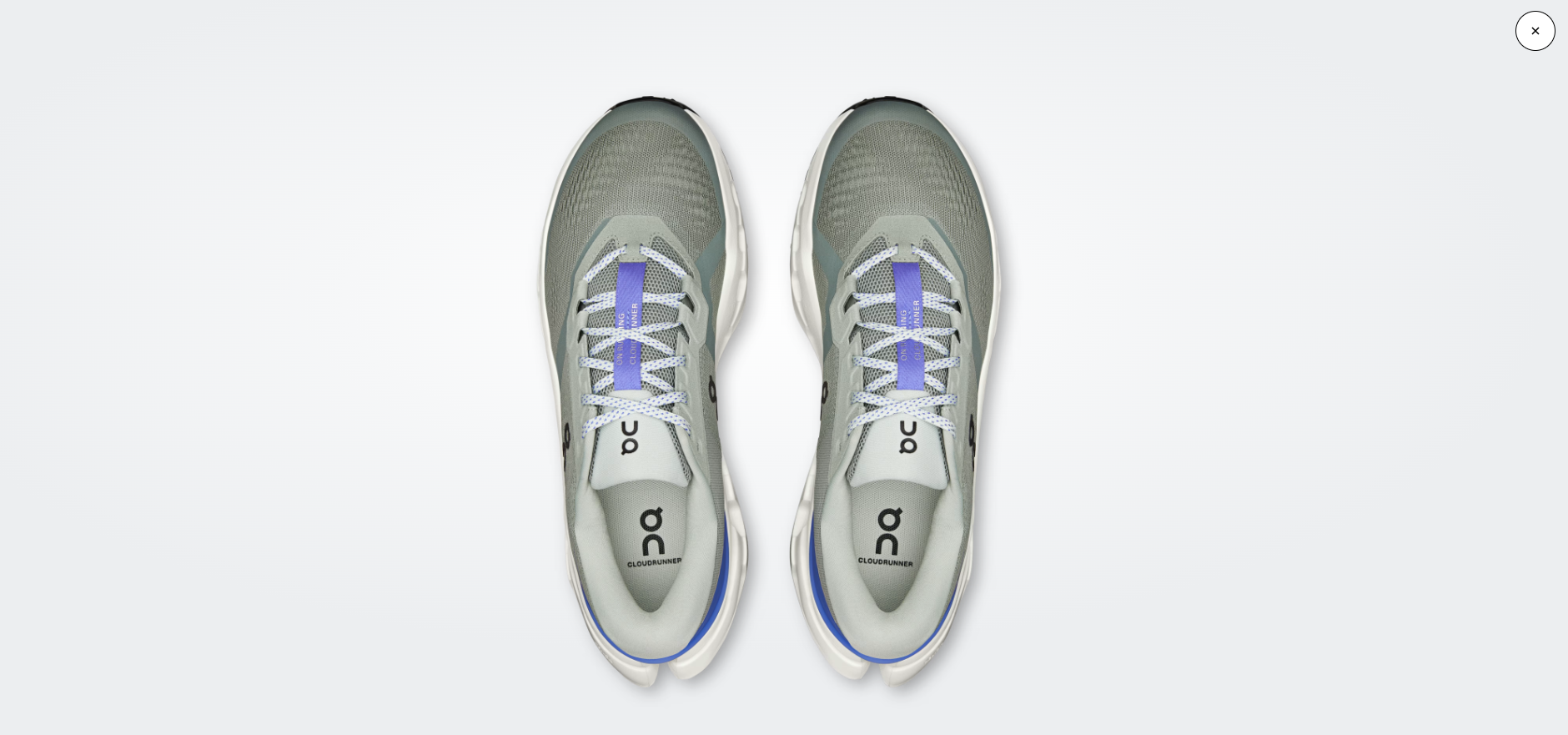 Sapatilhas desportivas cinza com detalhes azuis e atacadores brancos com padrão azul