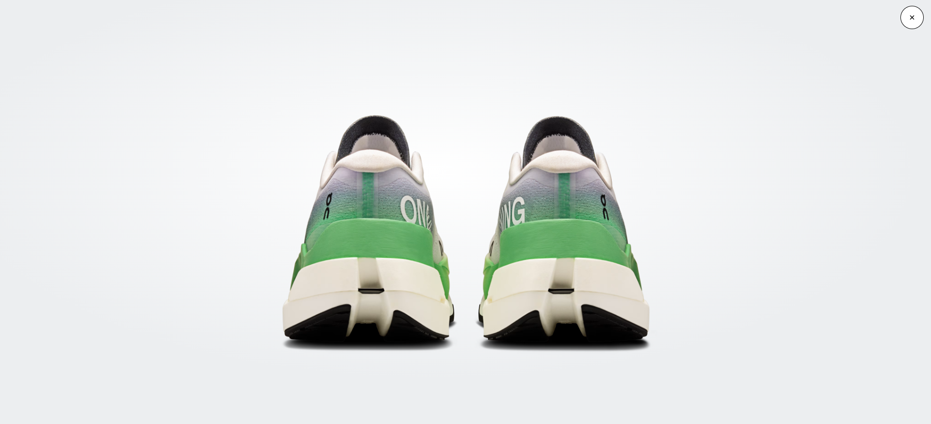 Sapatilhas desportivas verdes e brancas vistas de trás