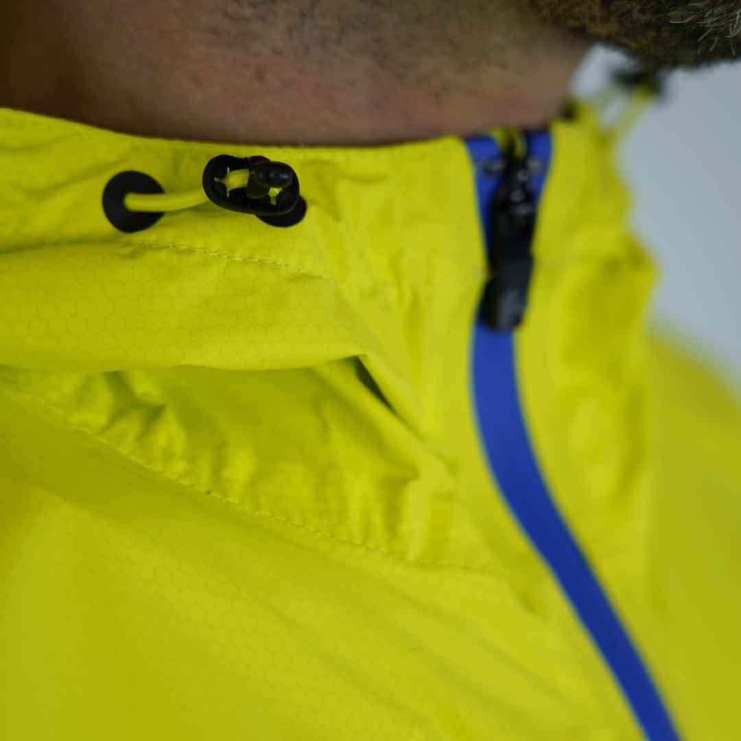 Jaqueta amarela com fecho azul e cordão de ajuste preto na gola