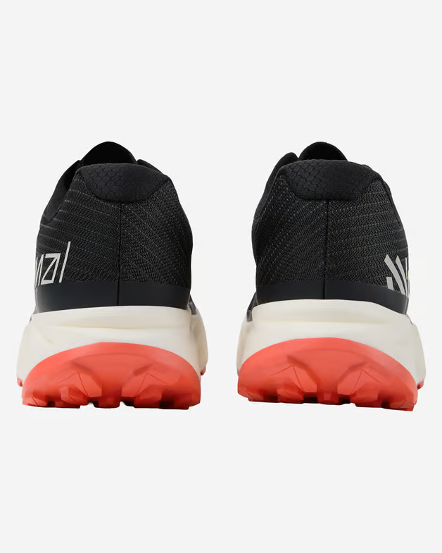 Ténis desportivos pretos vistos de trás, solo branco com sola exterior vermelha