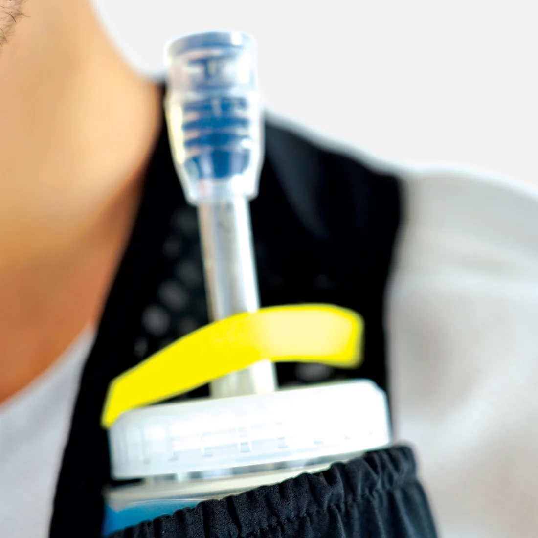 Garrafa desportiva com tampa branca e bico transparente em bolso preto