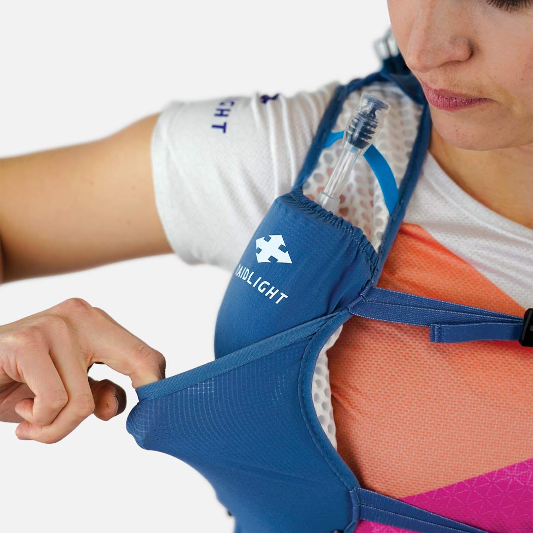 Colete de hidratação azul flexível usado por pessoa com camisa branca e estampada.