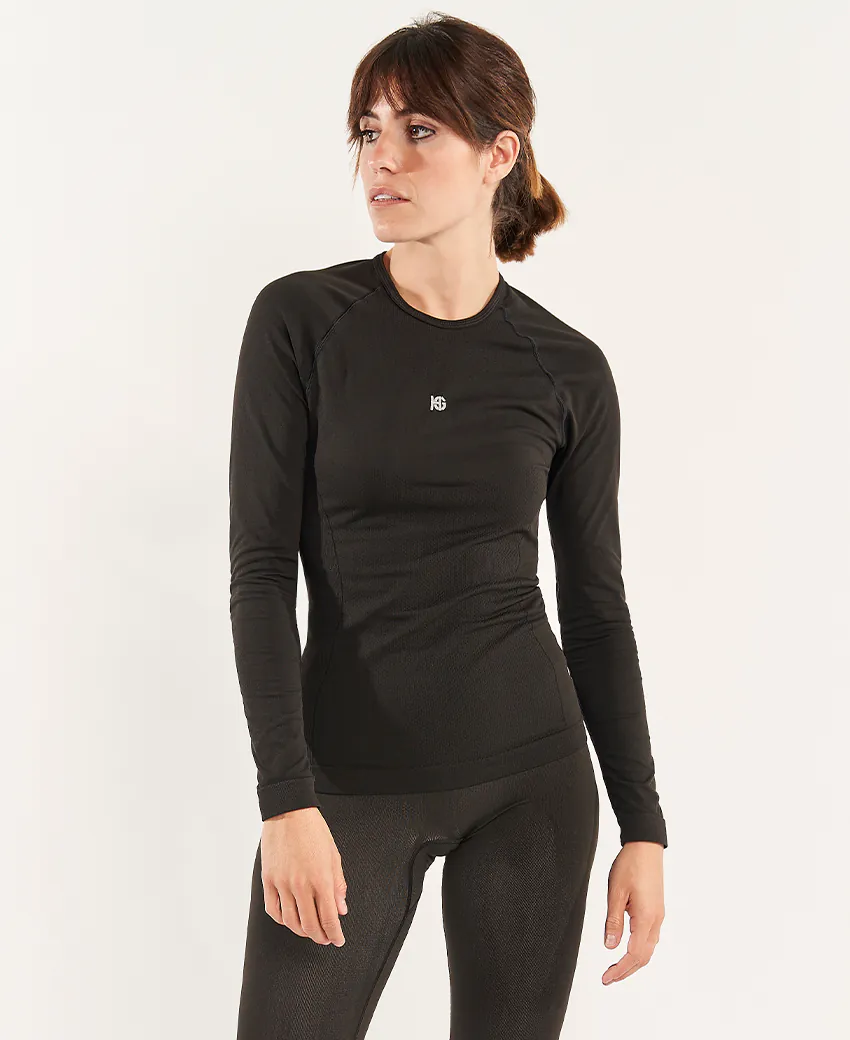 Mulher com conjunto desportivo preto, t-shirt de manga comprida e leggings justas