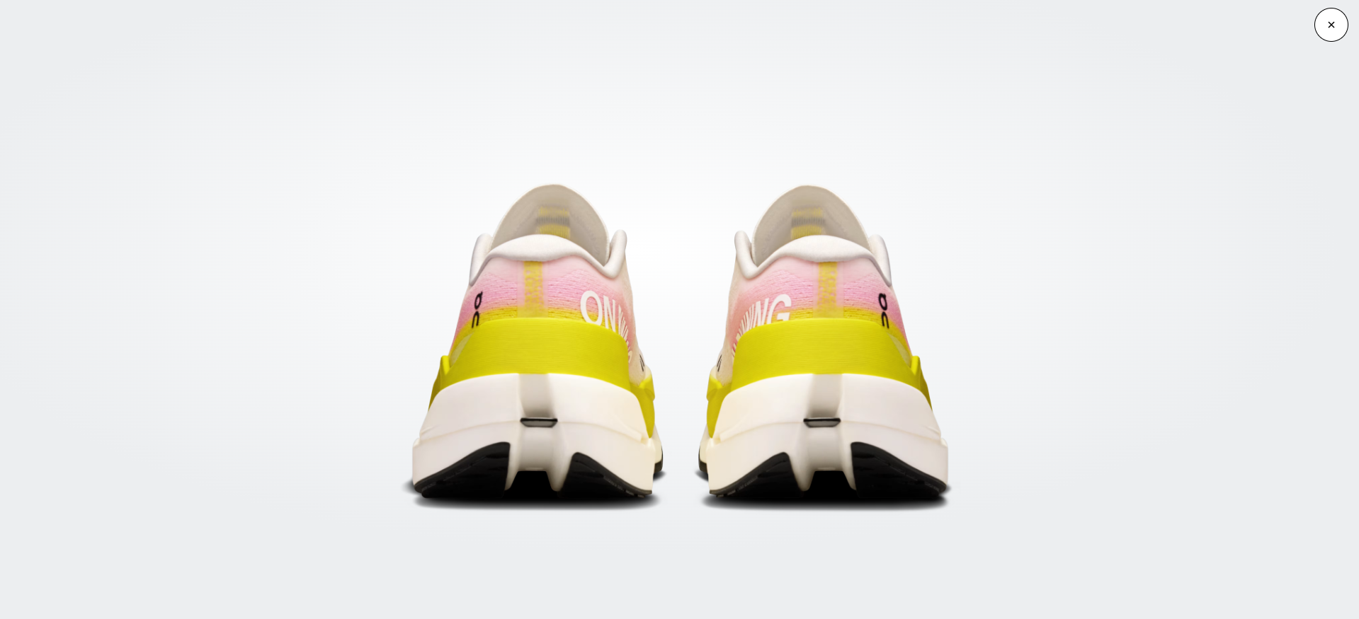 Par de sapatilhas desportivas amarelas, brancas e rosa vistas de trás