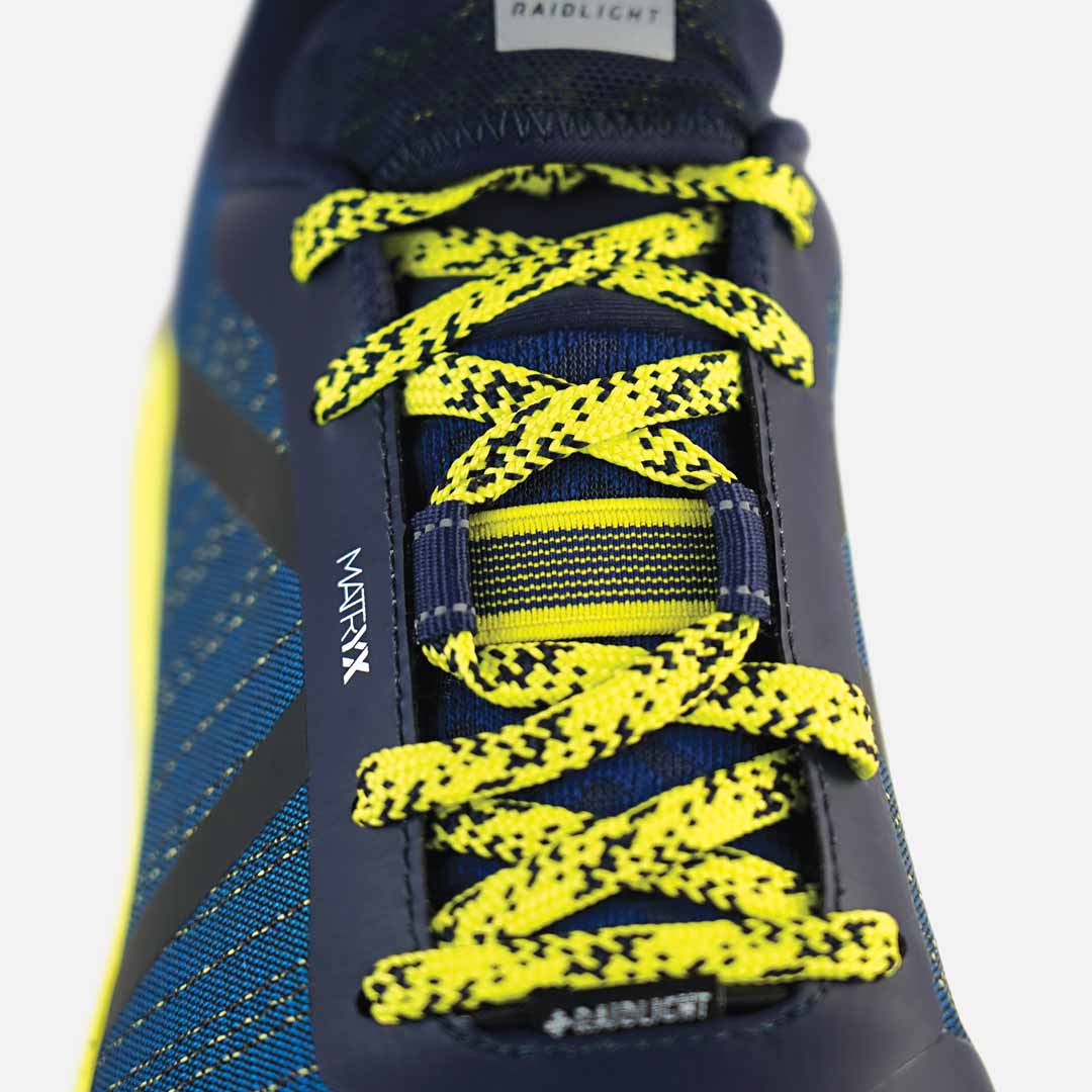 Sapatilha desportiva azul com atacadores amarelos e pretos e texto 'MAXTRAX' e 'BAIDLIGHT'.