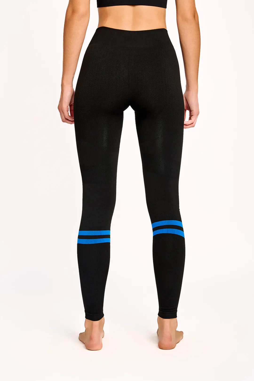 Leggings pretas com riscas azuis abaixo dos joelhos vistas de costas