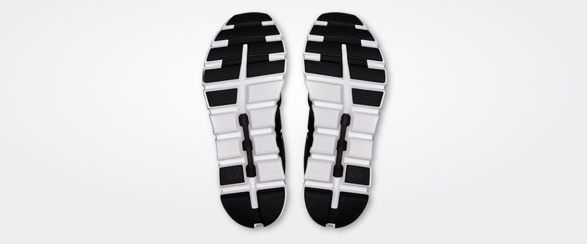 Solas de sapatos desportivos brancas e pretas com padrão em blocos.