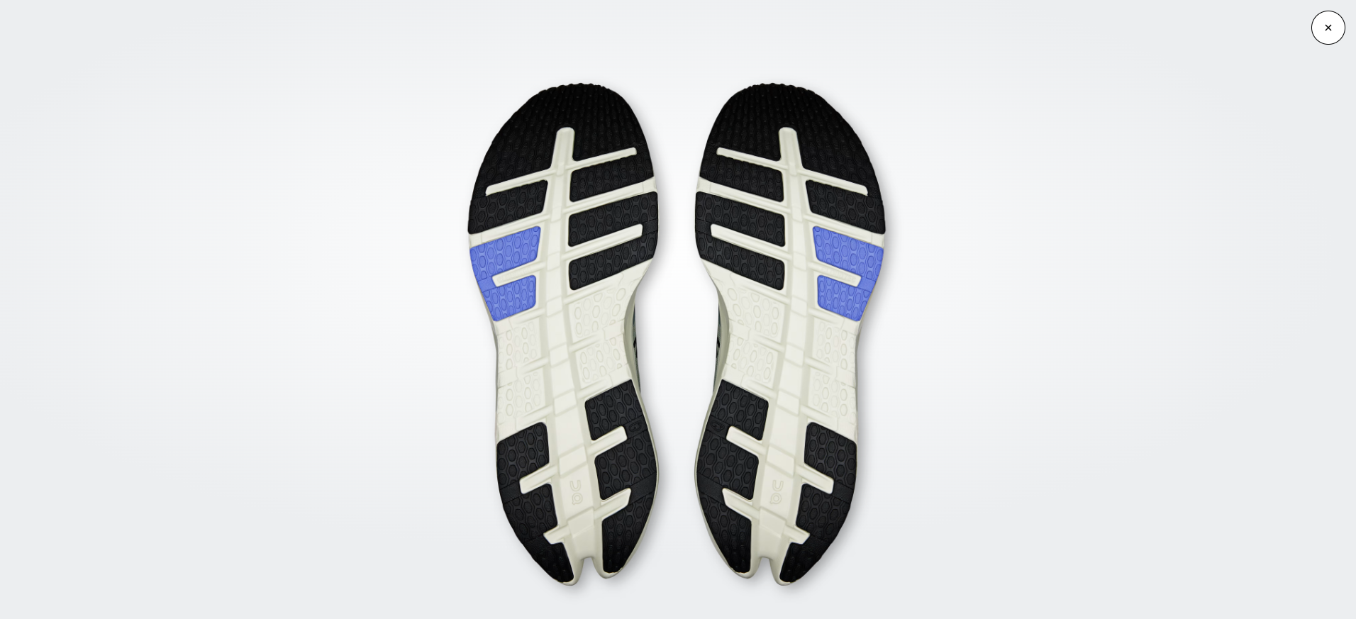 Solas de ténis preto, branco e azul vistas por baixo
